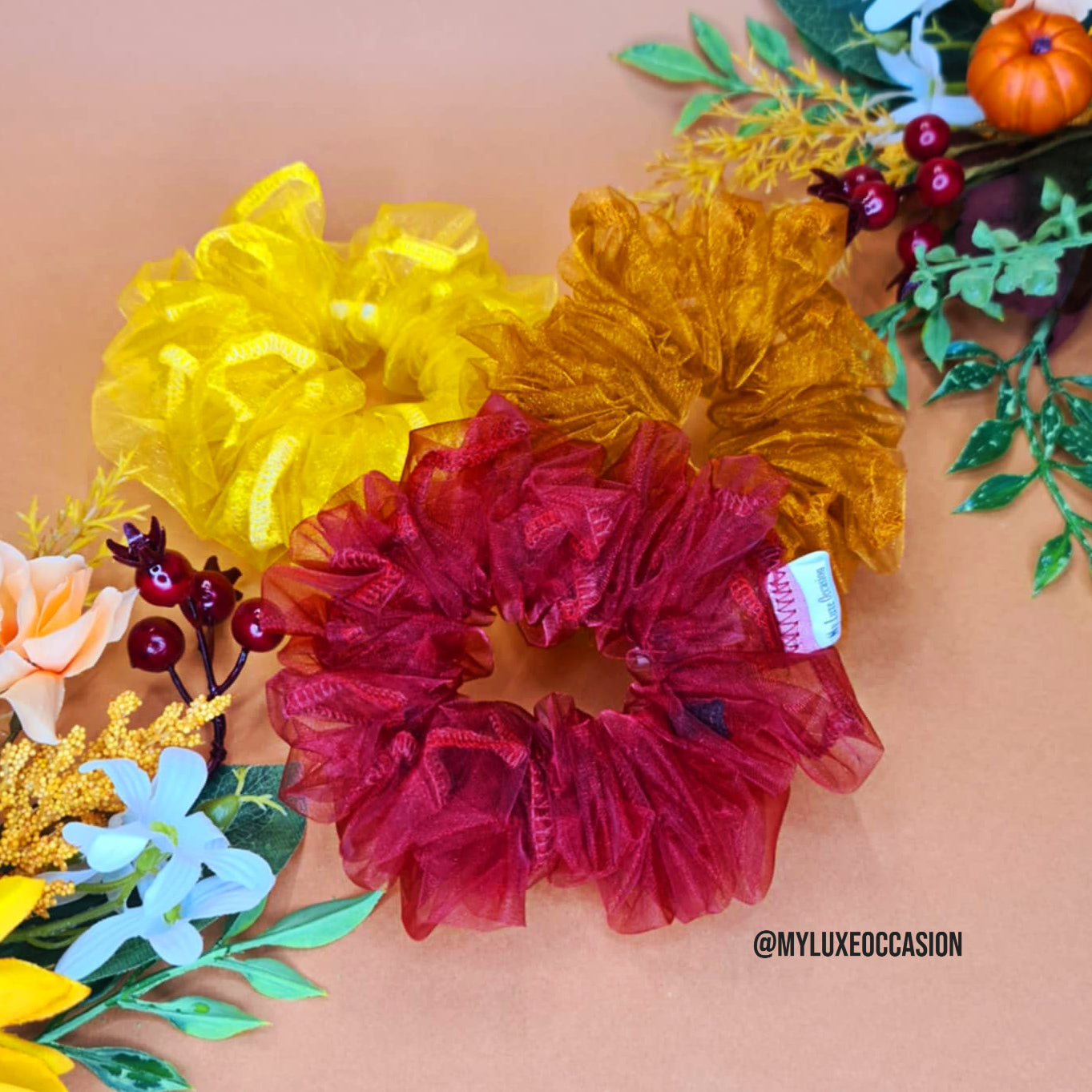 Organza scrunchies with decorative flowers on a peach background