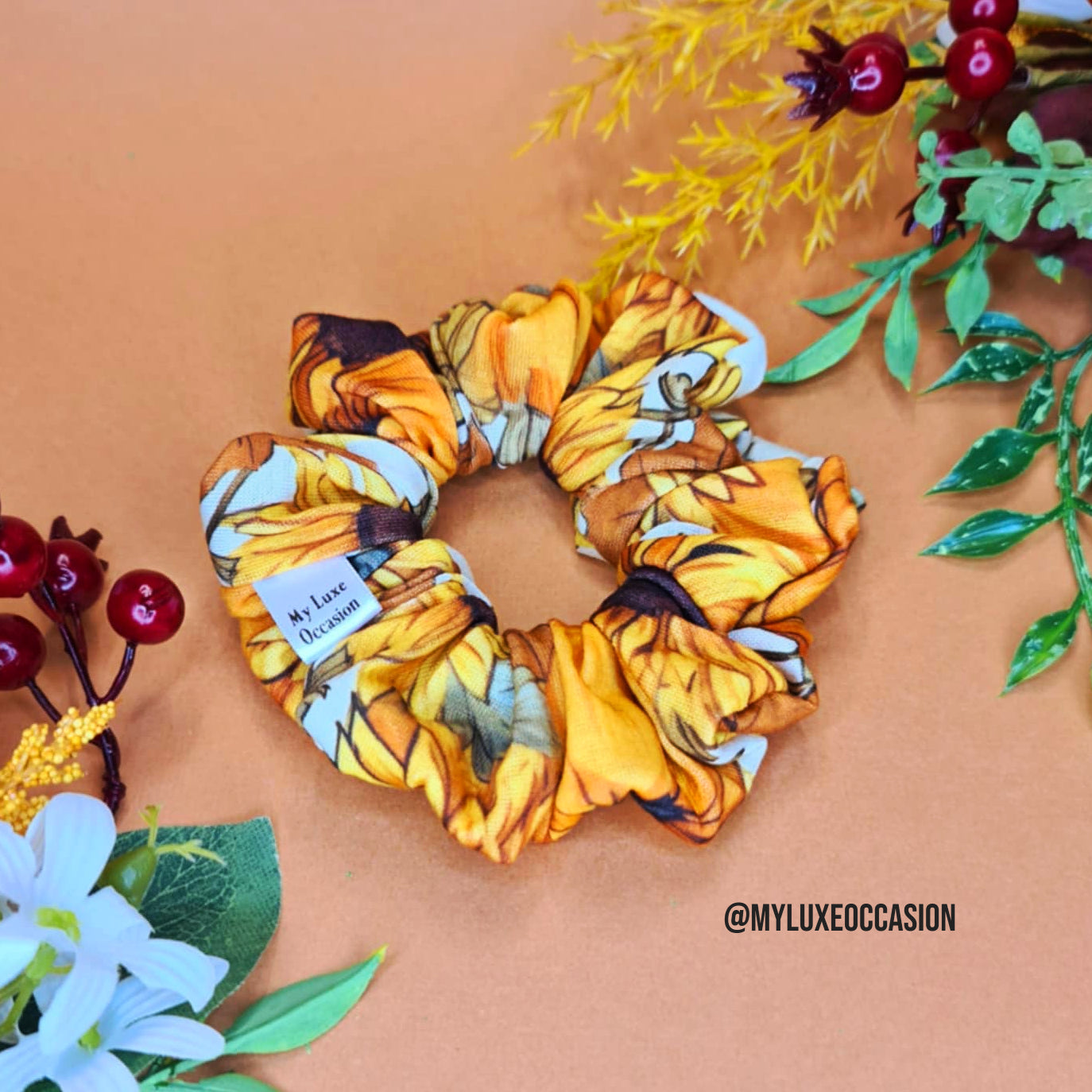 Sunflower-themed scrunchie on a brown background with floral decorations