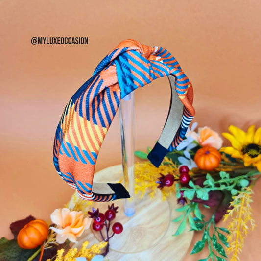 Colorful tartan headband with a floral and pumpkin decoration on a beige background
