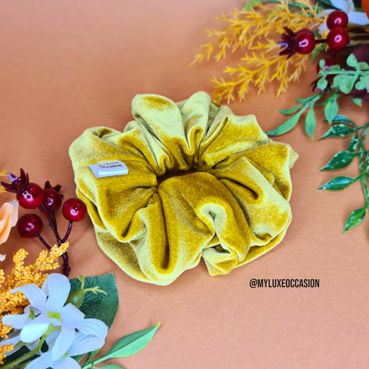 Yellow scrunchie on a peach background with floral decorations