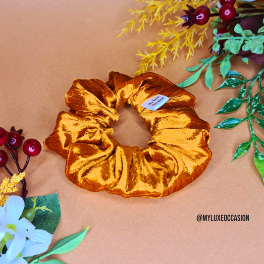 Orange scrunchie on a beige background with decorative elements