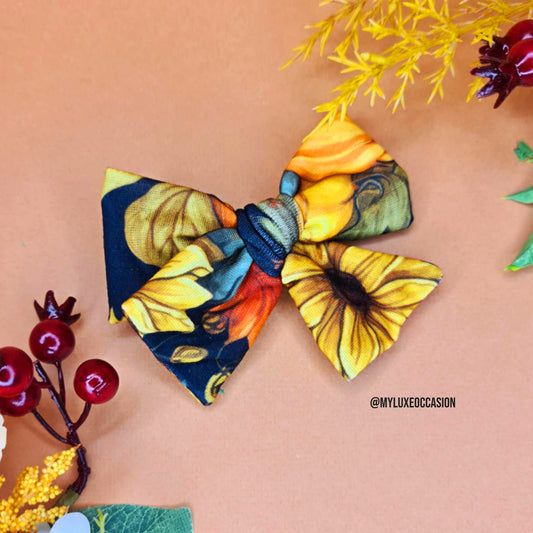 Colorful floral hair bow on a beige background with decorative elements.