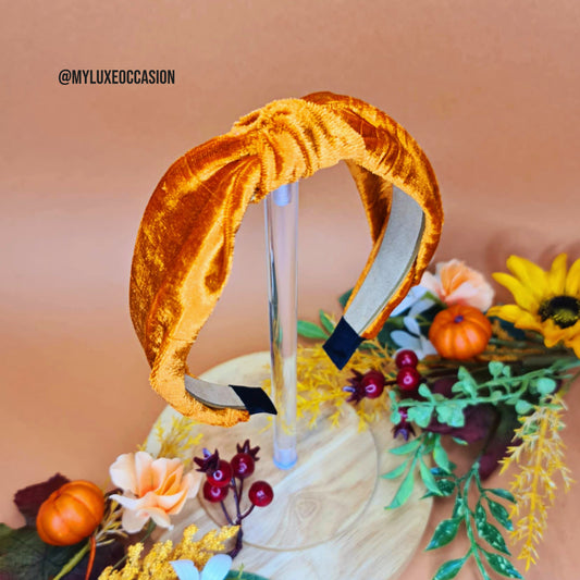 Orange velvet headband with a decorative background featuring flowers and pumpkins.