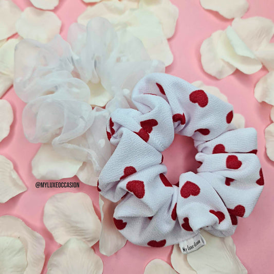 luxury heart print fabric scrunchie and white organza hair scrunchie on pink background with rose petals